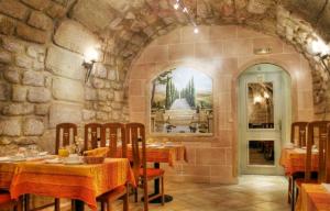 巴黎圣安妮卢浮宫酒店的石墙内带桌椅的餐厅