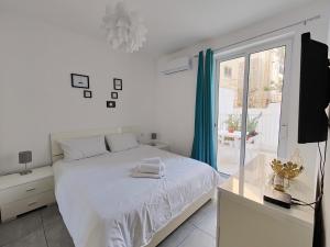 佩塔Large Central Apartment Near Valletta & Seafront的白色的卧室设有白色的床和窗户。