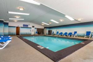 萨蒙阿姆SureStay Plus Hotel by Best Western Salmon Arm的一个带蓝色椅子的健身房内的游泳池