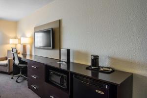 里贾纳东里贾纳司丽普酒店的酒店的客房设有一张桌子,墙上配有电视