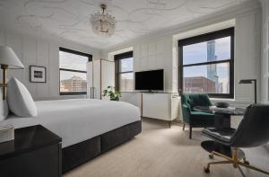芝加哥Pendry Chicago的酒店客房配有一张床、一张书桌和一台电视。