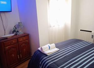 奥卡尼亚Acogedor Apartamento Ocaña的一间卧室配有床和带毛巾的梳妆台。