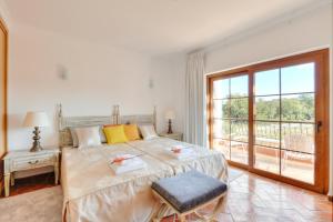 圣布拉什迪阿尔波特尔Quinta dos Tesouros的一间带大床的卧室和一个阳台