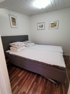 瓦尔贝里Tofta Konstgalleri-Hel Lägenhet 70kvm的白色墙壁和木地板的客房内的一张床位