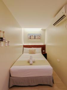 卡利博Hotel Simone Kalibo的一间小卧室,卧室内配有一张床铺
