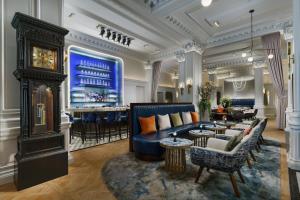 纽约时代广场阿尔冈昆酒店，傲途格精选酒店的酒店大堂设有蓝色的沙发和酒吧