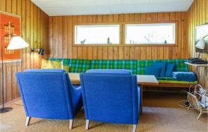 维斯特索马肯Gorgeous Home In Nex With Kitchen的一间带桌子和蓝色椅子的用餐室