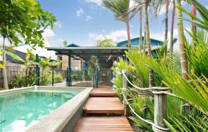 Machans BeachVilla Oshea - Balinese Beachfront Escape with Pool的一座带游泳池和木甲板的房子