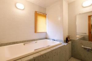 日光日光星之宿酒店(Nikko Hoshino Yado)的带浴缸、窗户和浴缸的浴室