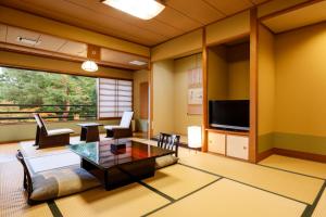 日光日光星之宿酒店(Nikko Hoshino Yado)的客厅配有桌子和电视
