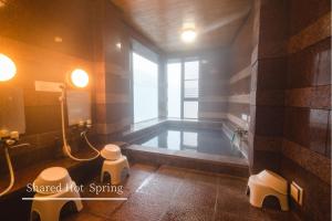 本宫Guest House Takiyoshi的一间带浴缸的浴室,位于一个窗口的房间