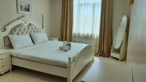 瓜埠Simfoni Resort Langkawi的一间卧室配有一张白色大床,床上有鲜花