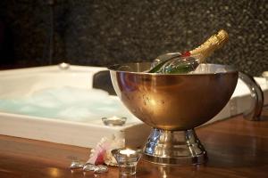 赫本温泉Kudos Villas - Hepburn Springs的浴缸配有一桶水和一瓶葡萄酒