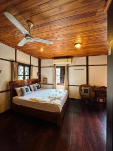琅勃拉邦Khounphet Heritage House的一间卧室设有一张木天花板床。