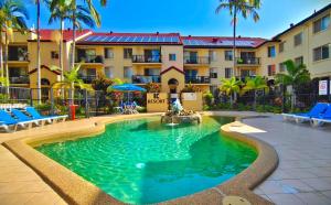 黄金海岸K Resort Surfers Paradise Apartments的棕榈树建筑前的游泳池