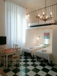 比萨Eco Pisa Tower Guesthouse的一间卧室配有两张床、一张桌子和一张书桌