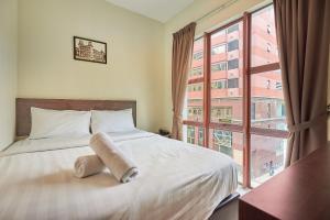 吉隆坡Swing & Pillows - Adya Hotel Kuala Lumpur的一间卧室设有一张床和一个大窗户