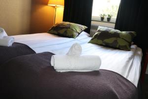 诺尔雪平Hotell Drott的坐在酒店房间床上的毛巾动物