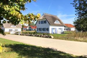 特伦特Haus in idyllischer Lage mit Sauna, Terrasse und Garten - Villa Morgensünn的白色的房子,有灰色的屋顶和车道