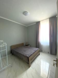 第比利斯Cozy House Tbilisi的一间卧室设有一张床和一个窗口