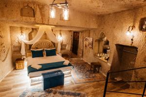 于尔居普Bayar Cave Suites的一间卧室配有一张床和一个壁炉。