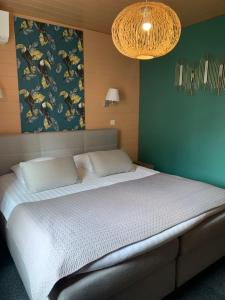 希伯维列Hotel SPA Restaurant Au Cheval Blanc的一间卧室设有一张大床和绿色的墙壁