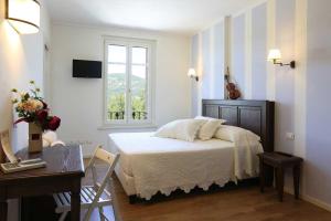 帕尔马Villa Gelsomina的一间卧室配有一张床、一张书桌和一个窗户。