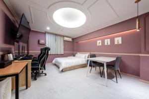 仁川市Incheon BoscoHotel的酒店客房,配有一张床、一张桌子和椅子