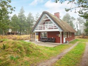 托弗图姆Modern Holiday Home in Rømø with Sauna的一座带茅草屋顶的红色小房子