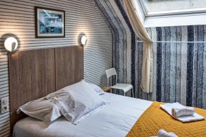 康卡勒Hotel La Voilerie Cancale bord de mer的酒店客房配有一张床铺和一张桌子。