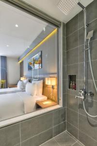 芽庄Maris Hotel Nha Trang的一间卧室设有一张大床和淋浴