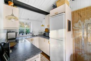 海斯勒Cozy Holiday Home Close To Forest And Beach的厨房配有白色橱柜和白色冰箱。