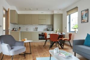 伦敦Hammersmith Mews by Viridian Apartments的厨房以及带桌椅的起居室。