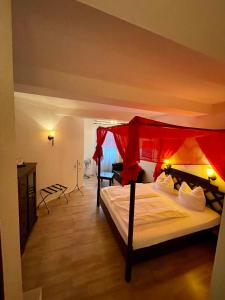 新维德Hotel zur Römerbrücke的一间卧室配有一张红色天蓬床