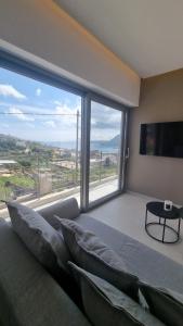 干尼亚Marigold Apartments的卧室设有大窗户、沙发和电视。
