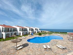 卡拉恩·布拉內斯RVHotels Sea Club Menorca的一个带游泳池和椅子的度假胜地和大海