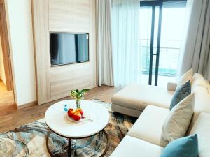 下龙湾HB Serviced Apartment - Alacarte Hạ Long的客厅配有白色的沙发和桌子