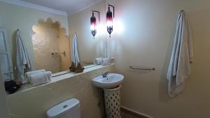 马拉喀什里亚德雨果摩洛哥传统庭院住宅旅馆的一间带水槽、卫生间和镜子的浴室
