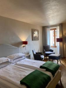 利莫内-苏尔加达Casa L'Andrunèl的卧室配有一张白色大床和绿色毛巾