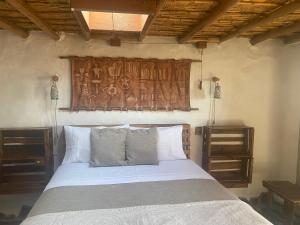 La HuaicaEl Huarango Eco retreat的一间卧室配有一张带木制床头板的床