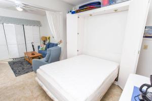 沃尔顿堡滩Bayou Dwellers Cabana Colony #6的卧室配有白色的床和蓝色椅子