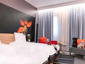 米兰米兰诺富特利纳德机场酒店的配有一张床和一把椅子的酒店客房