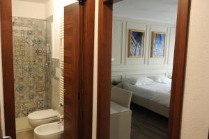 佛罗伦萨pontevecchio rooms的浴室设有床、卫生间和水槽。