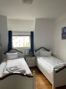 特罗辛根Linde Restaurant & Hotel的卧室设有两张单人床和窗户。