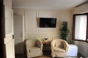 佛罗伦萨pontevecchio rooms的客厅配有两把椅子和电视