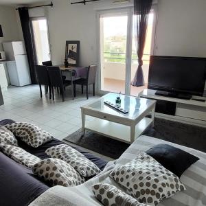 FonsorbesSpacieux appartement résidence calme的客厅配有沙发和带枕头的桌子