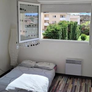 FonsorbesSpacieux appartement résidence calme的一间小卧室,配有床和窗户