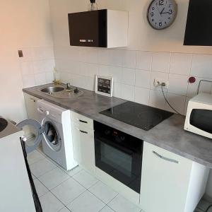 FonsorbesSpacieux appartement résidence calme的厨房配有洗衣机和水槽