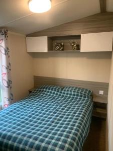 Wyke RegisLittlesea haven Rachel’s retreat的一间卧室配有一张带蓝色格子布毯的床