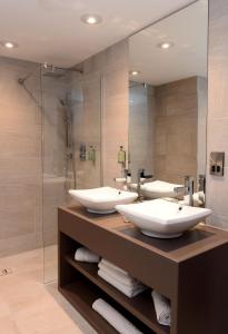特尔福德假日特尔福德铁桥酒店的一间带三个盥洗盆和淋浴的浴室